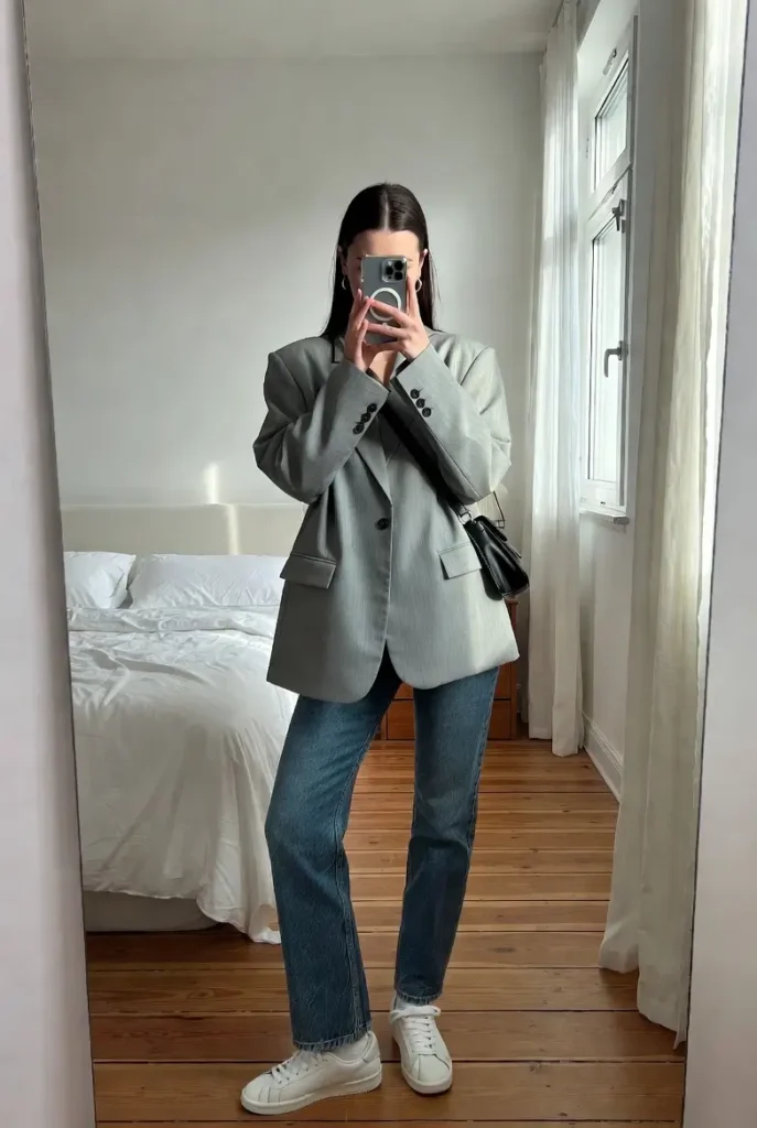 Polished casual style in 10 Clean Girl Outfit Ideas featuring an oversized grey blazer and blue jeans.
