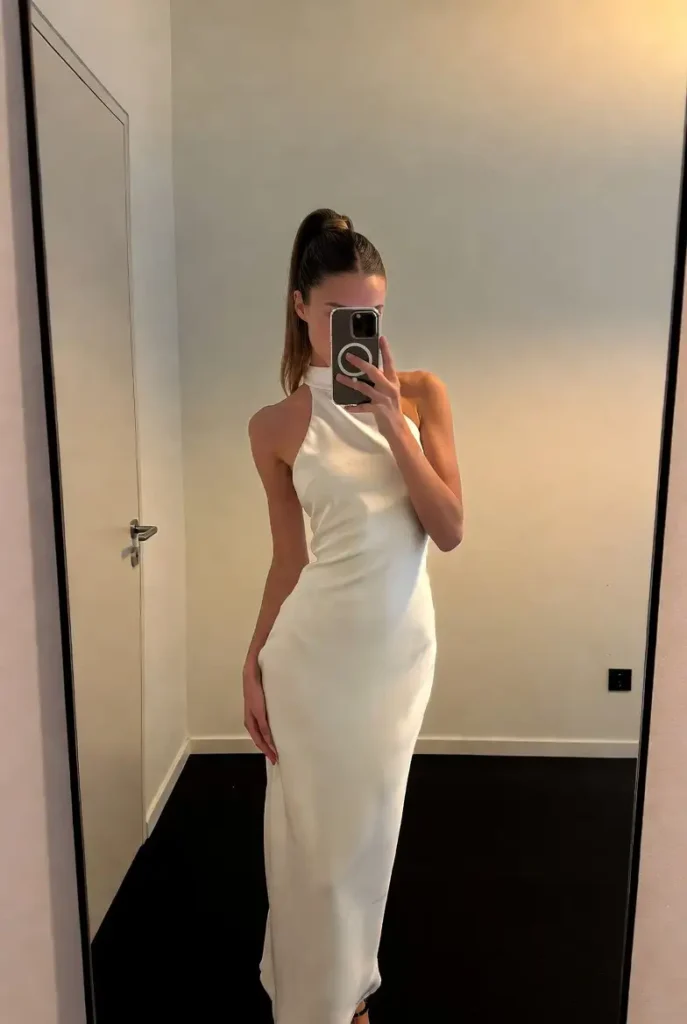A chic white halter dress; a sophisticated choice for our 15 White Dress Outfit Ideas collection.