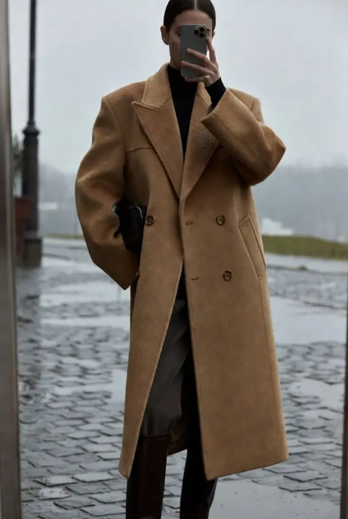 From 10 dark academia outfit ideas: oversized camel wool coat over black turtleneck with knee-high boots