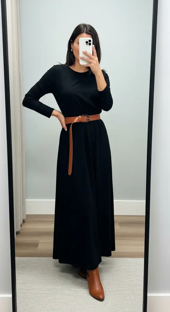 Black maxi dress casual outfit idea cinched with a brown leather belt and paired with tan ankle boots