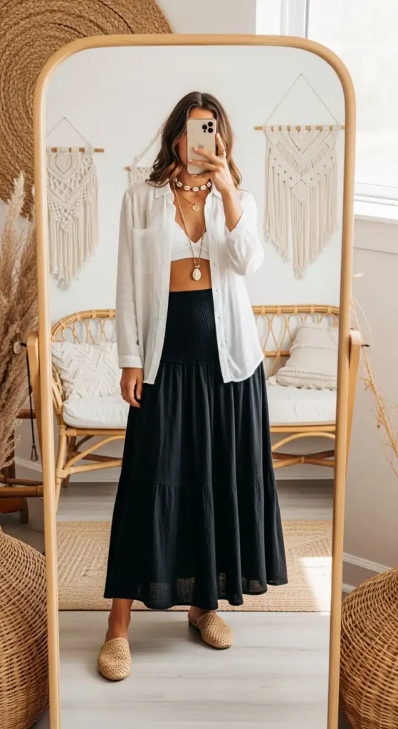 Mirror selfie showing a casual black long skirt outfit idea for summer — white sheer top over bralette with mules