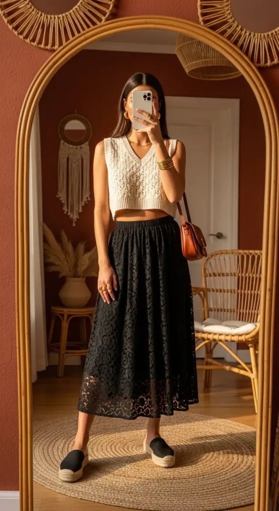 Boho mirror selfie showing a knit vest black lace skirt outfit idea for summer with espadrilles
