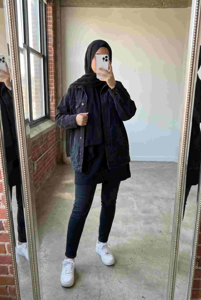 Black denim jacket with skinny jeans and white sneakers — casual black outfit ideas for women with hijab