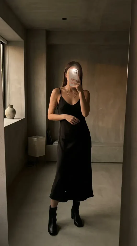 Casual Outdoor Pre-Wedding Outfit Ideas: black satin slip dress with ankle boots and layered gold necklaces