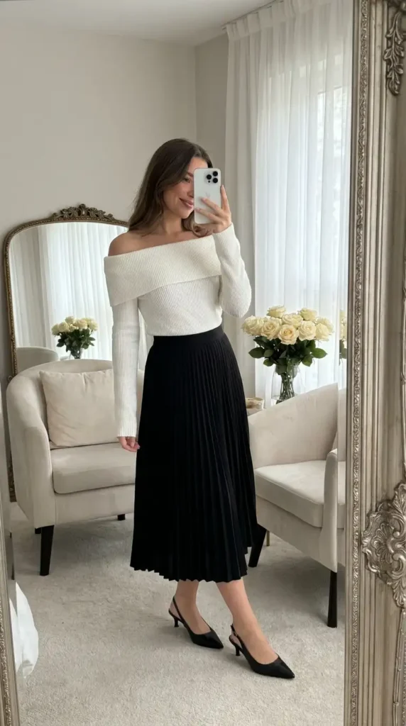 Black and White Outfit Ideas for Birthday Parties: white off-shoulder knit top with a flowing black pleated midi skirt.