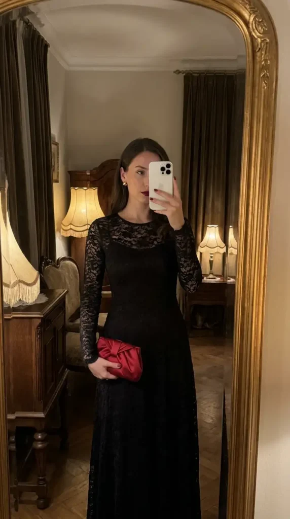 Elegant black lace gown with a red satin clutch, a timeless red and black outfit idea for party events.
