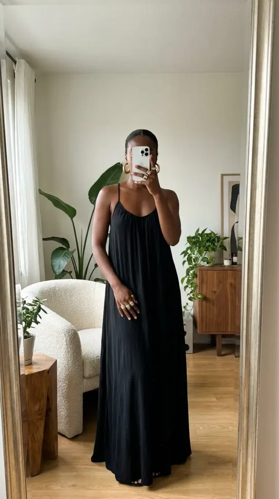 Flowy black maxi dress with large gold hoop earrings, graceful black and gold outfit ideas for black women.