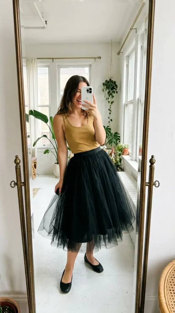 Casual black and gold party outfit ideas featuring a voluminous black tulle midi skirt paired with a gold ribbed tank top.
