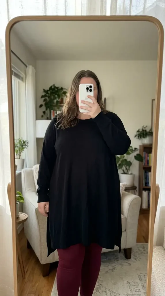 Red and black outfit ideas for plus size: long black sweater tunic paired with fitted dark red leggings.
