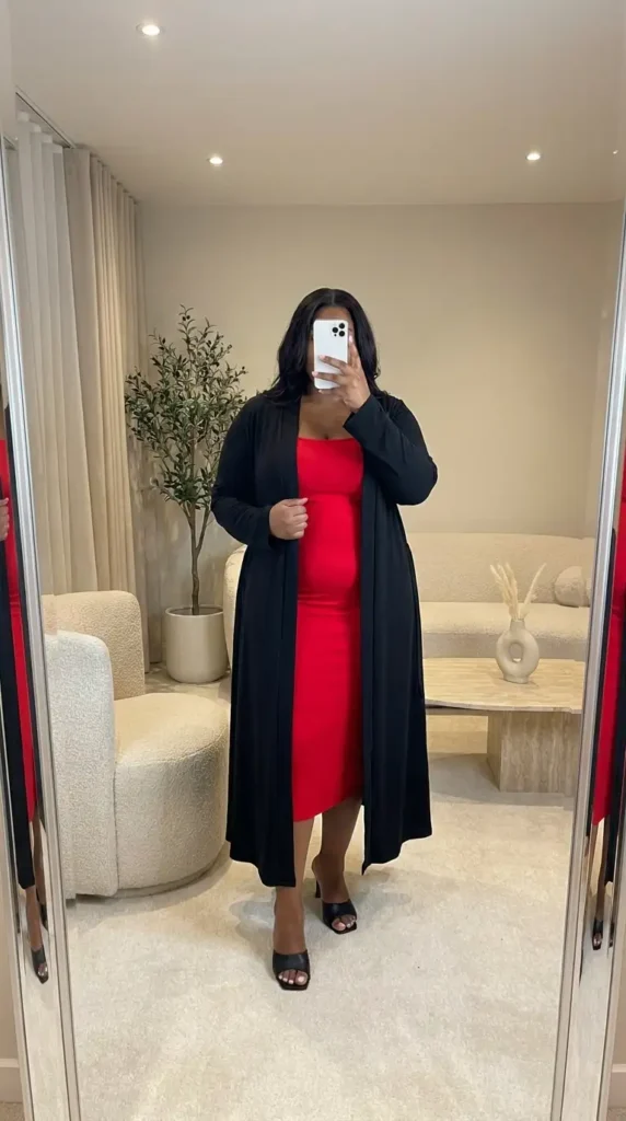 Red and black outfit ideas for plus size: red bodycon midi dress under a flowy black duster cardigan with mules.
