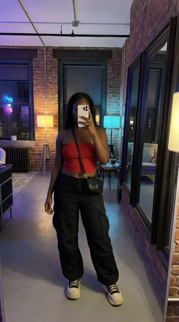 Red tube crop top with black cargo pants and sneakers – summer red and black outfit ideas for black women
