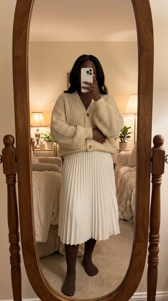 Cream knit cardigan with white pleated skirt – soft All White Fall Outfit Ideas for Black Women.