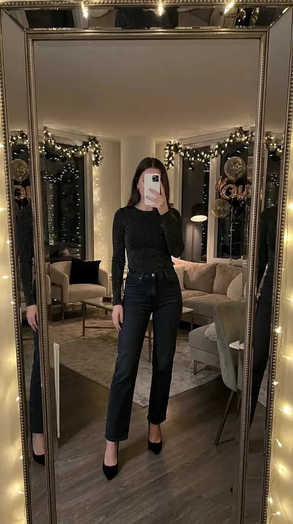 Woman in sparkly black top, straight-leg jeans and heels for New Year Outfit Ideas Parties.