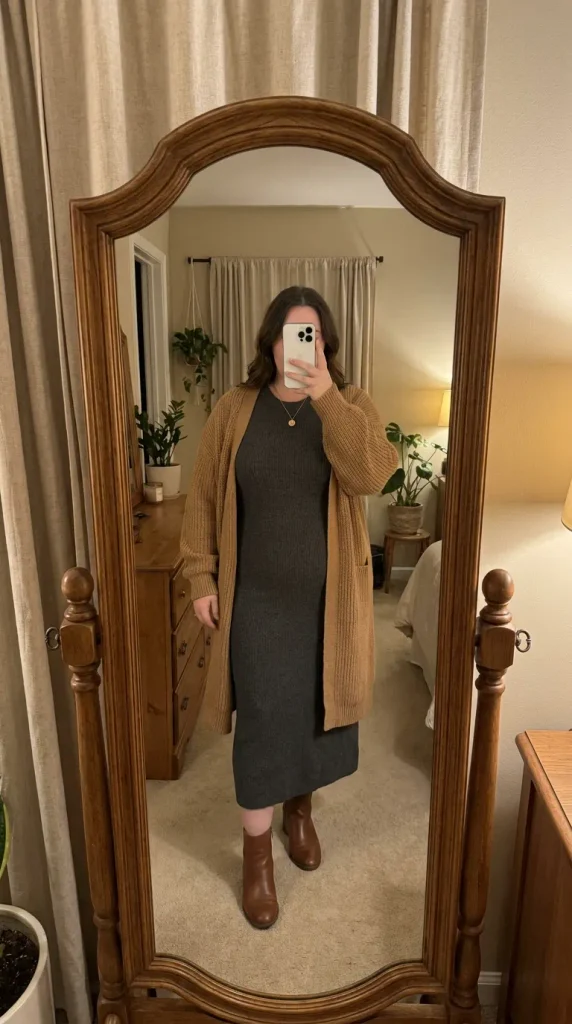 Plus size woman in grey column dress with longline camel cardigan and boots, cozy New Year Eve Outfit Ideas for Plus Size Women.