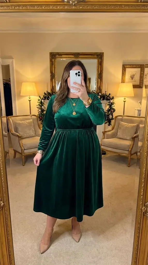 Plus size woman in emerald velvet midi dress and nude pumps, elegant New Year Eve Outfit Ideas for Plus Size Women look.